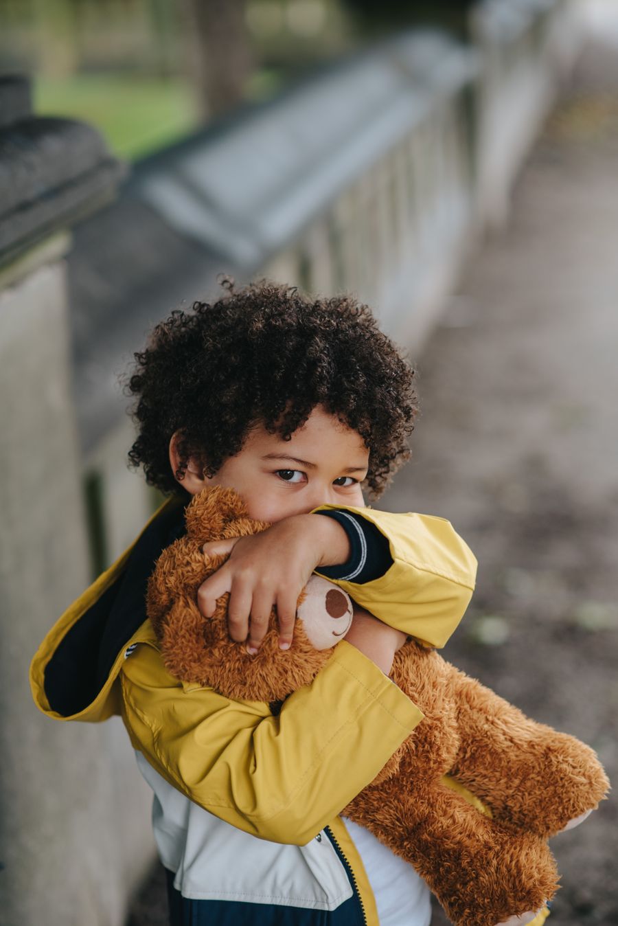 A smiling child hugging a teddy bear