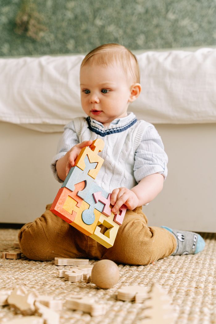An infant playing with wooden toys