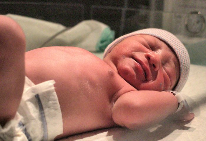A newborn baby swaddled in a hospital blanket